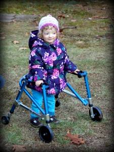 Fiona standing on grass with her walker.